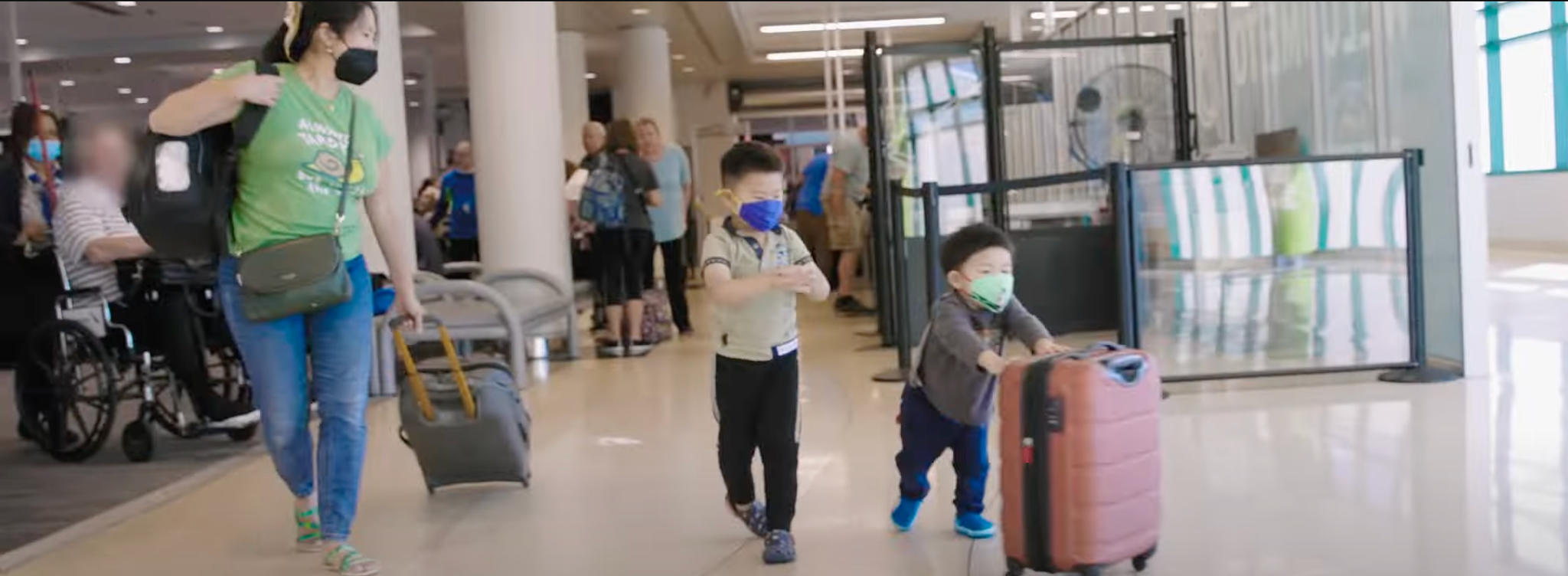 child-pushes-carry-on-bag-in-terminal