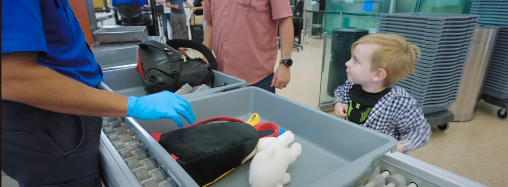 child-puts-backpack-into-bin-at-airport-security