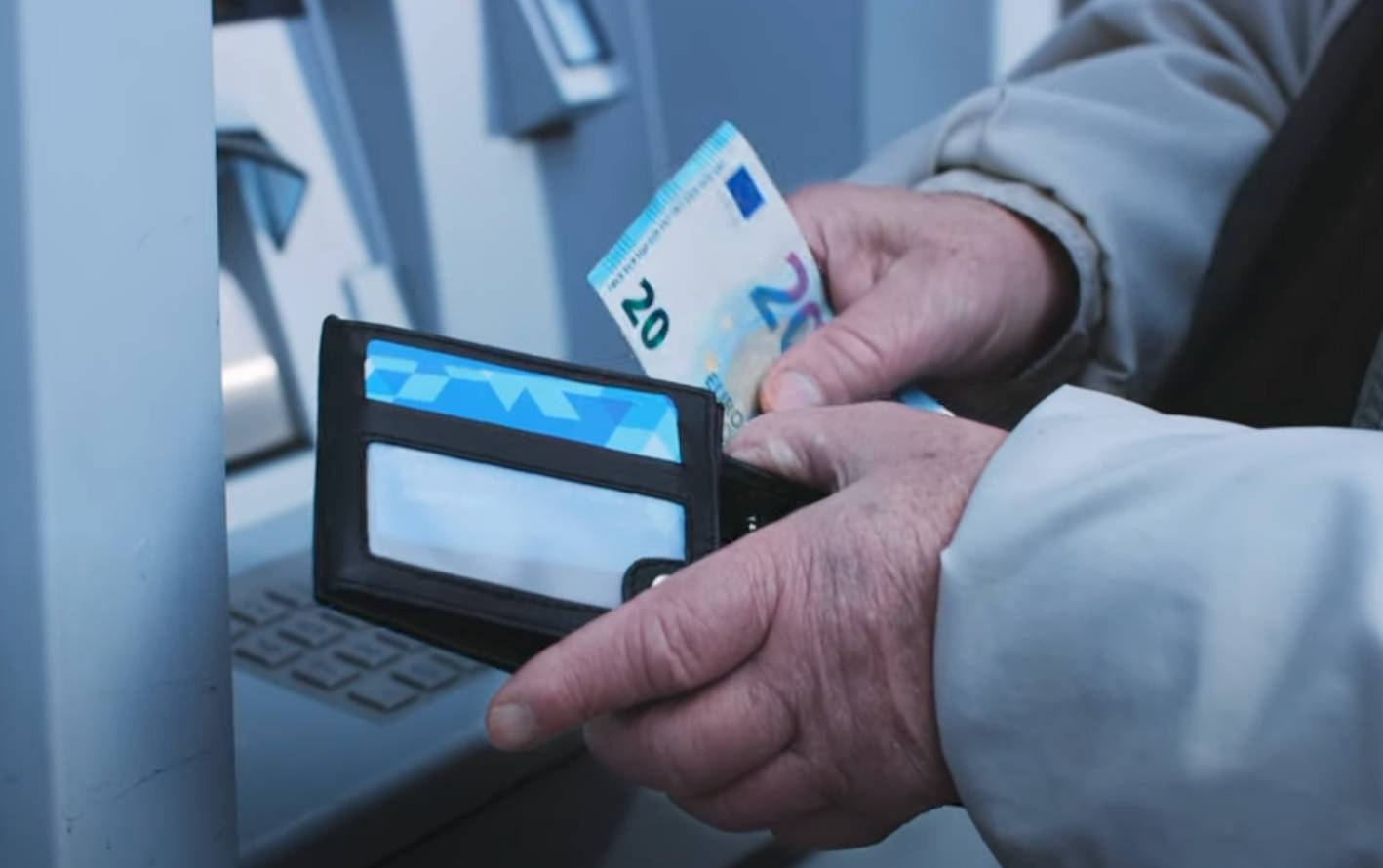 ATM machine at an airport with a person withdrawing cash