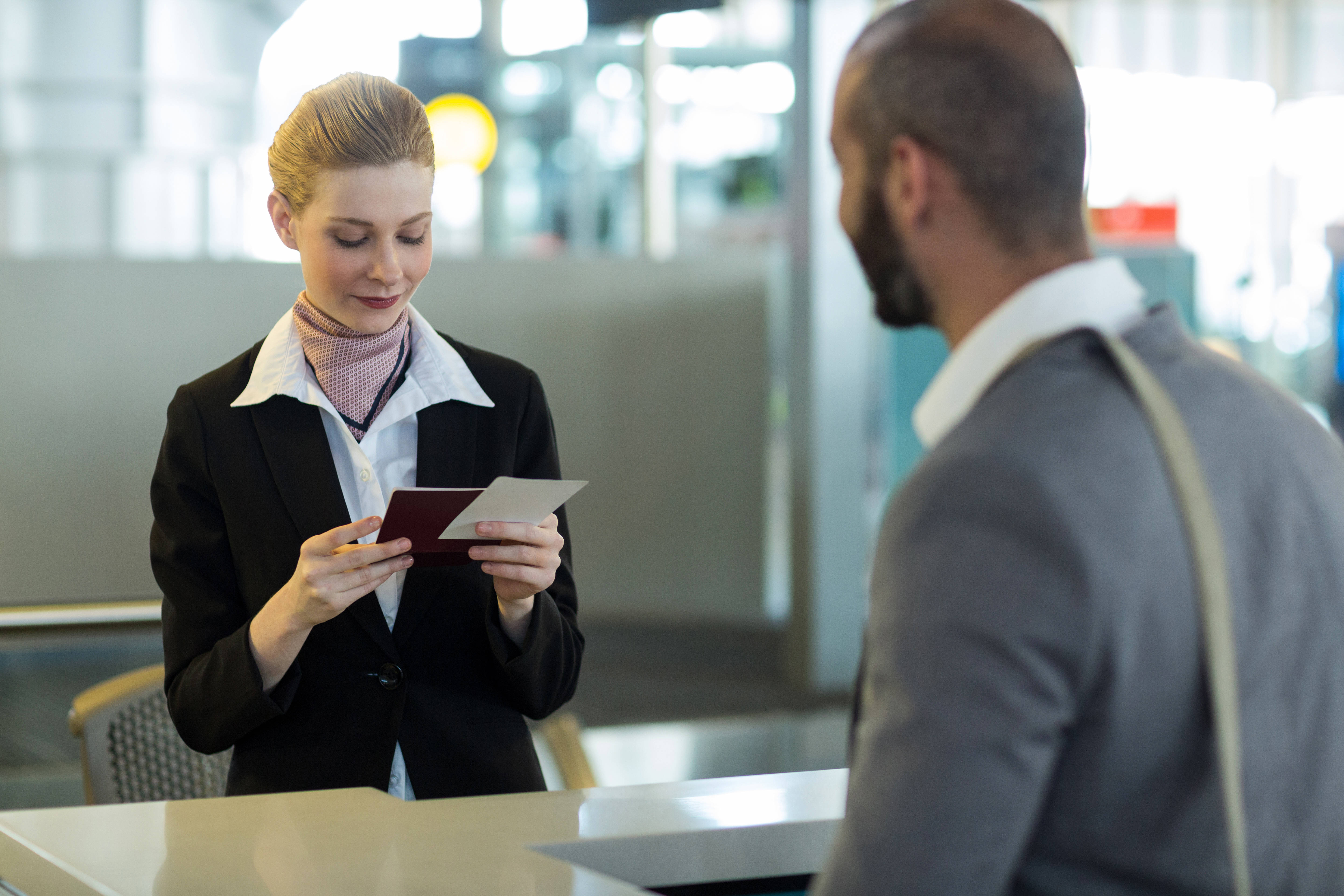 Commuter standing at counter while attendant checking his passport