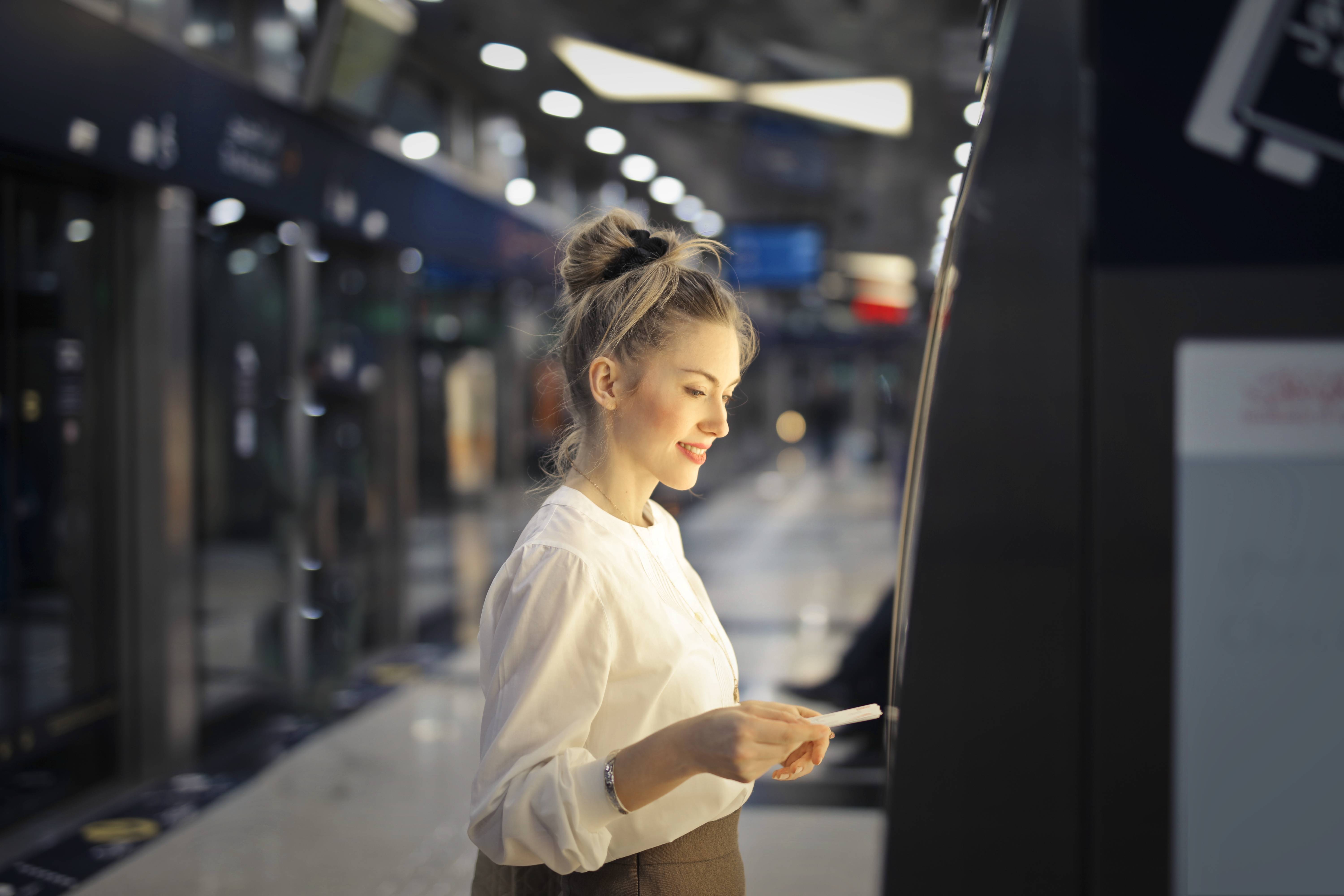 Woman purchasing a ticket at a subway station kiosk