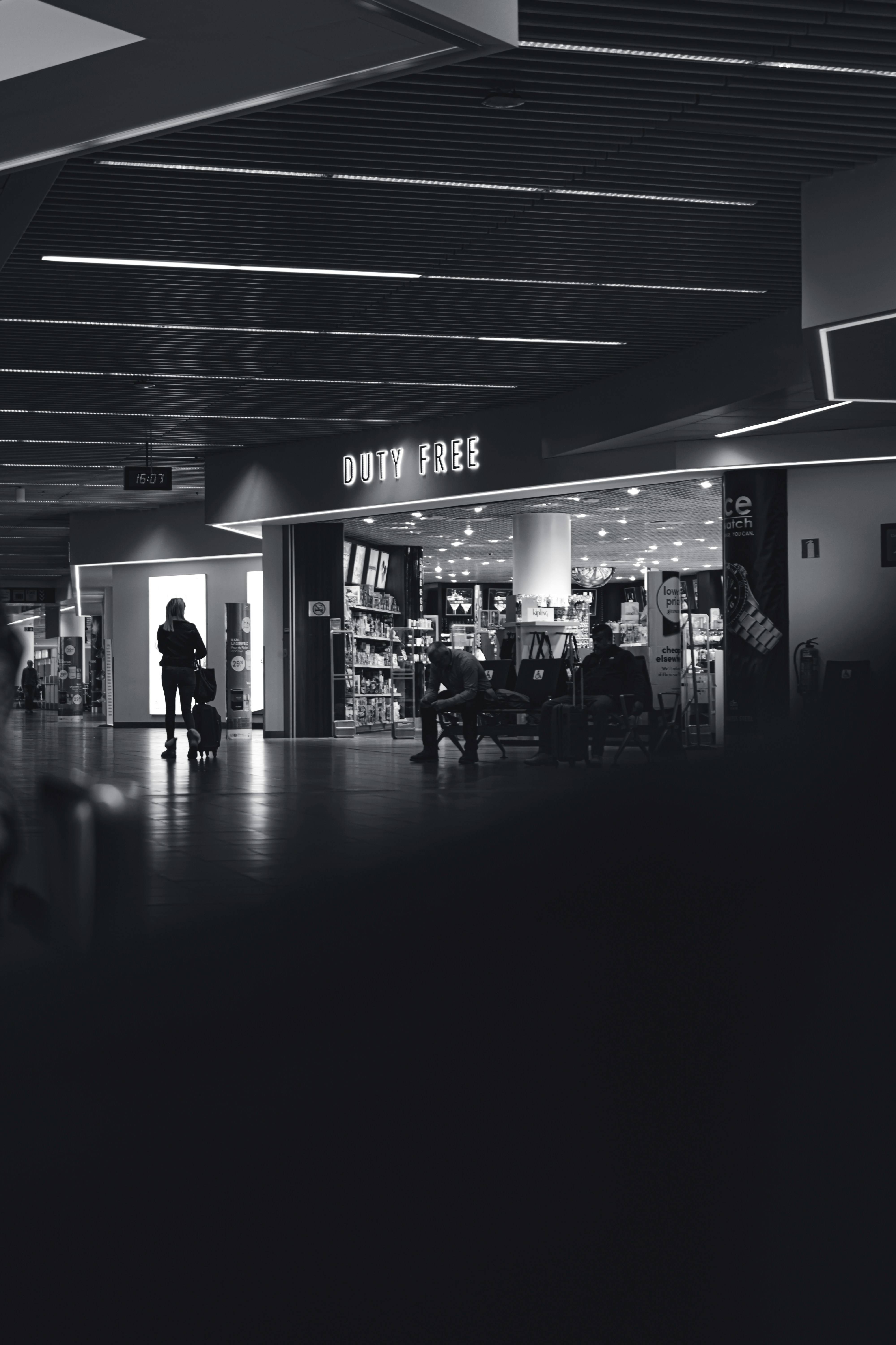 Black and white photo of people walking through an airport terminal