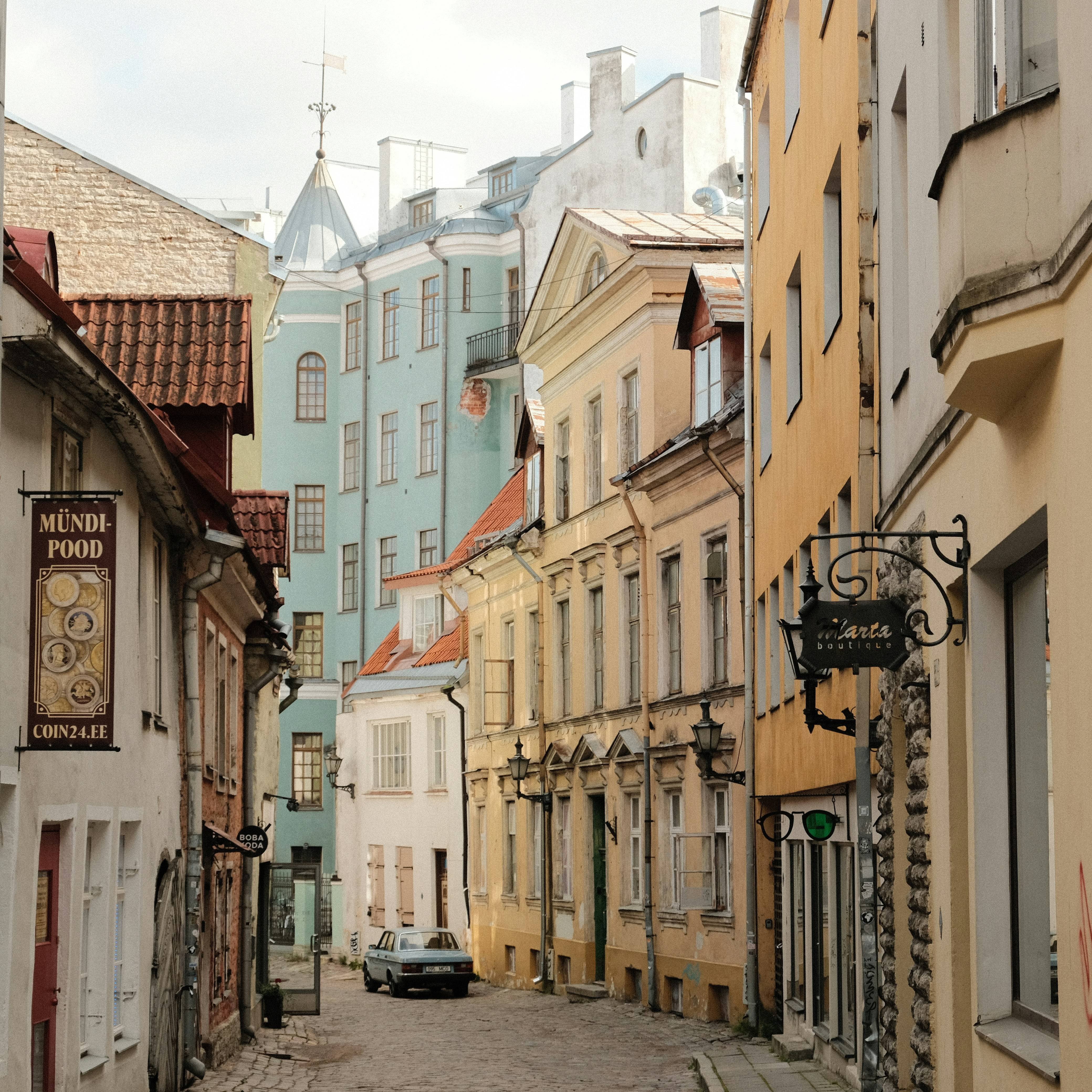 a car is parked on the side of a narrow street