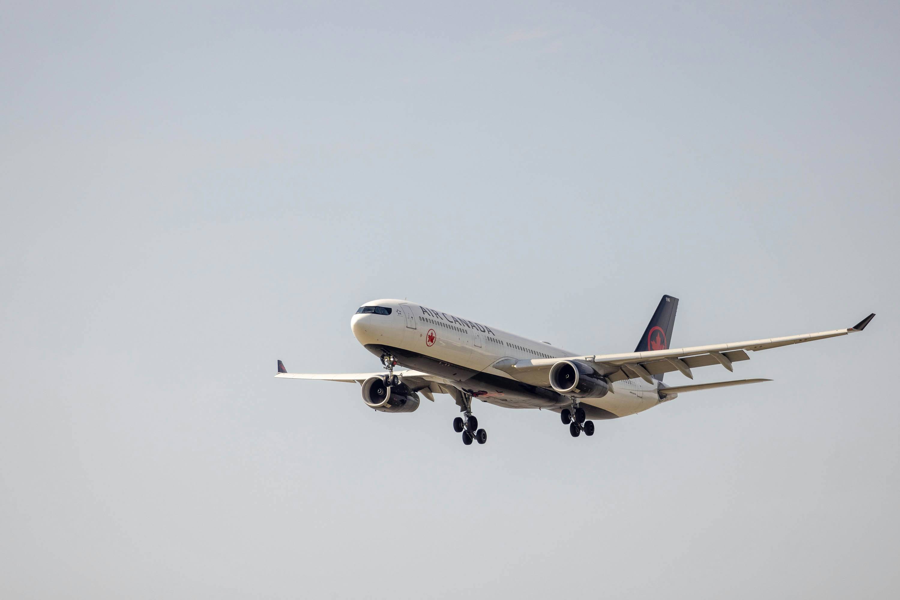 a large jetliner flying through a gray sky