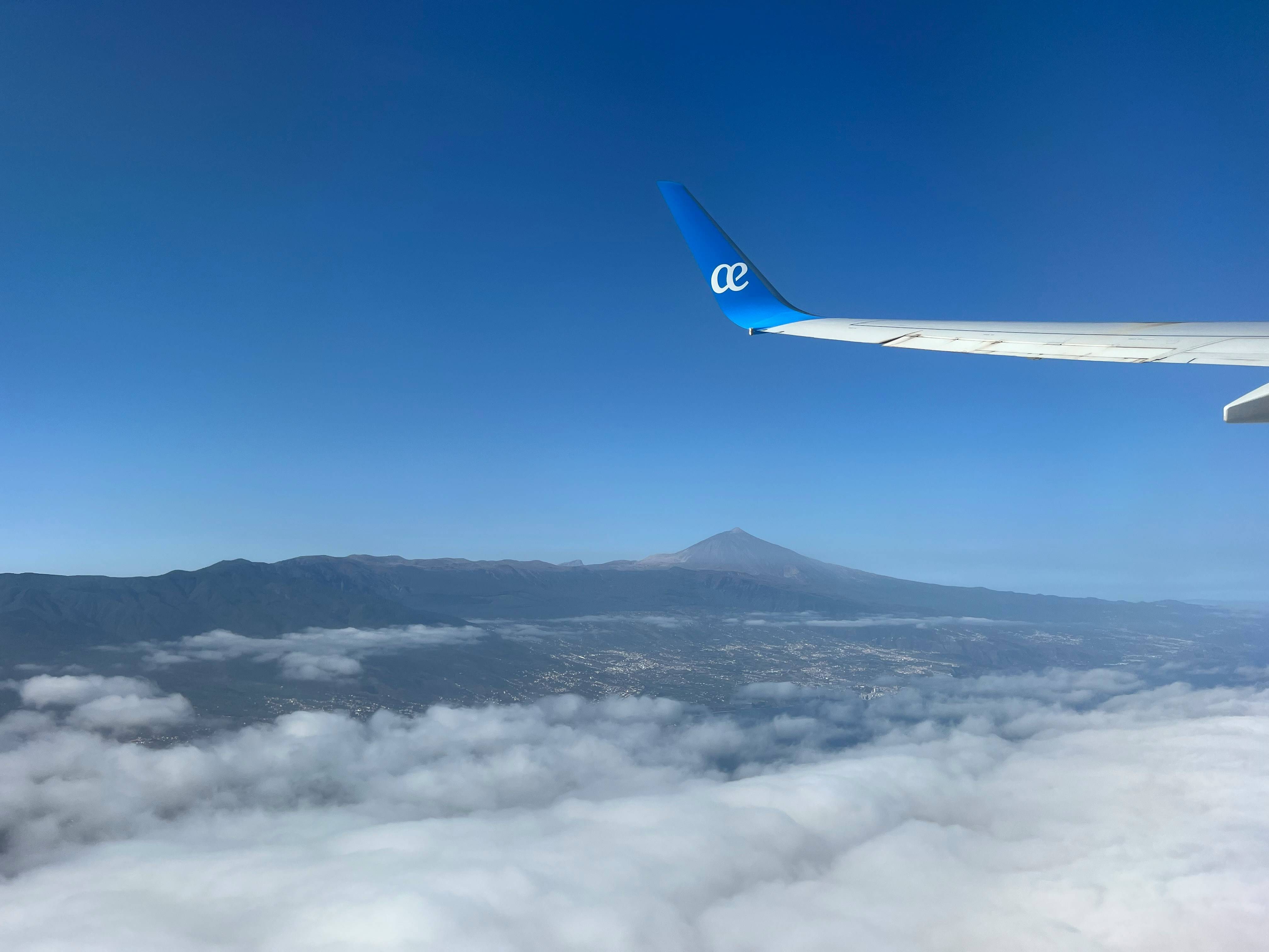 a view of the wing of an airplane flying above the clouds