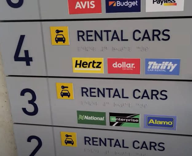 Airport rental car levels sign with directional arrows and icons