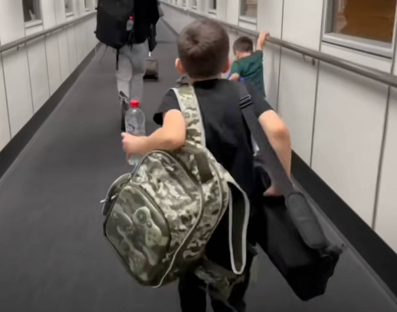 kids-carrying-carry-on-bags-in-jetway