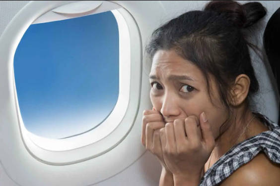 woman in fear next to plane window afraid to fly