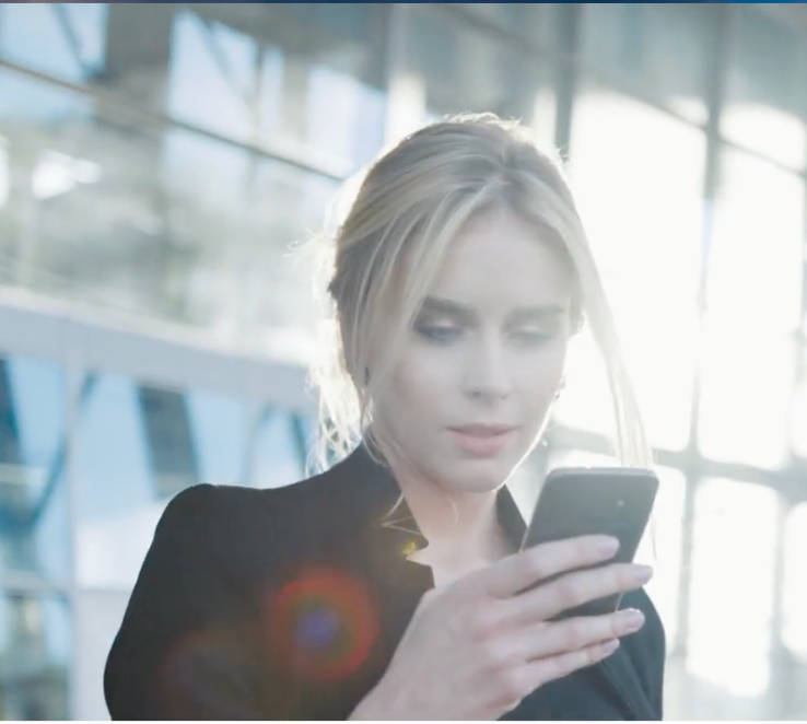 Woman using a phone to navigate through an airport terminal